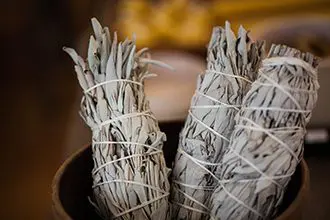 A close up of some white sage in a bowl