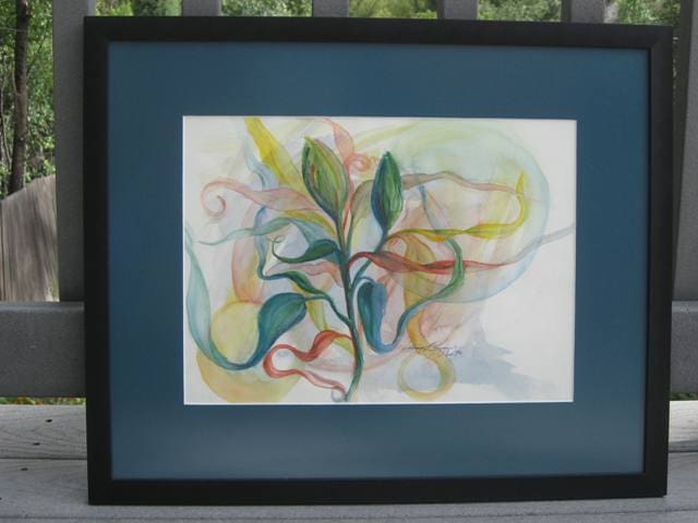 A painting of leaves and swirls in a black frame.